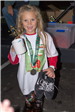 Young Girl Holding a Mug, Trophy, and Shoes